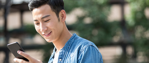 A young man looking at his cell phone.