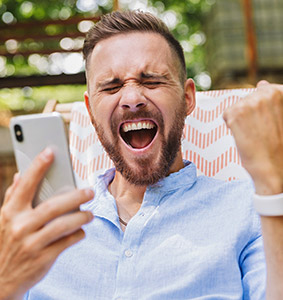 A man with happy expression holding a phone.