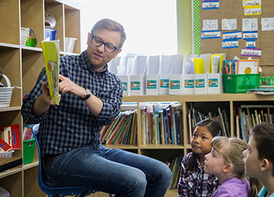 A teacher reading to young students.