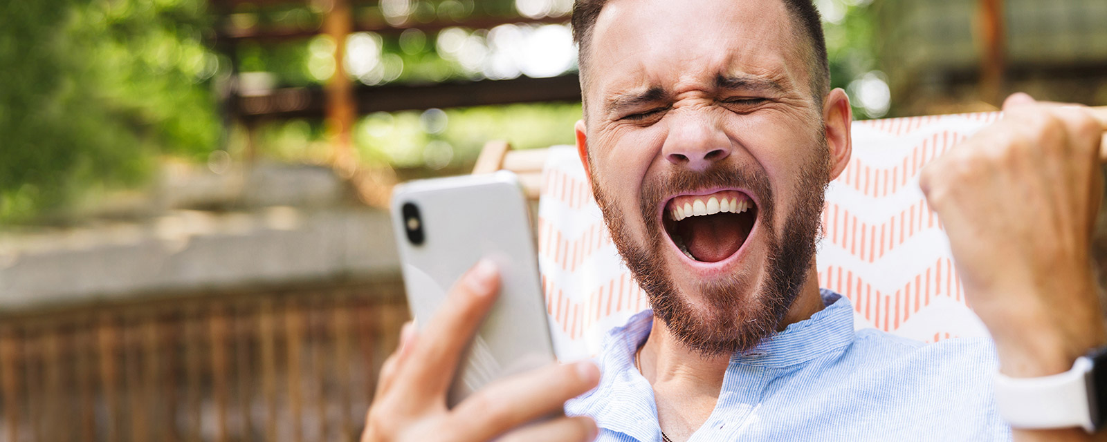 A man with a happy expression holding a phone.